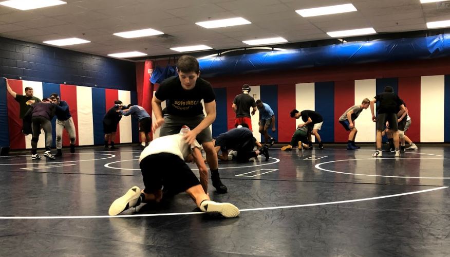 The wrestling team practices in the wrestling room after school.
