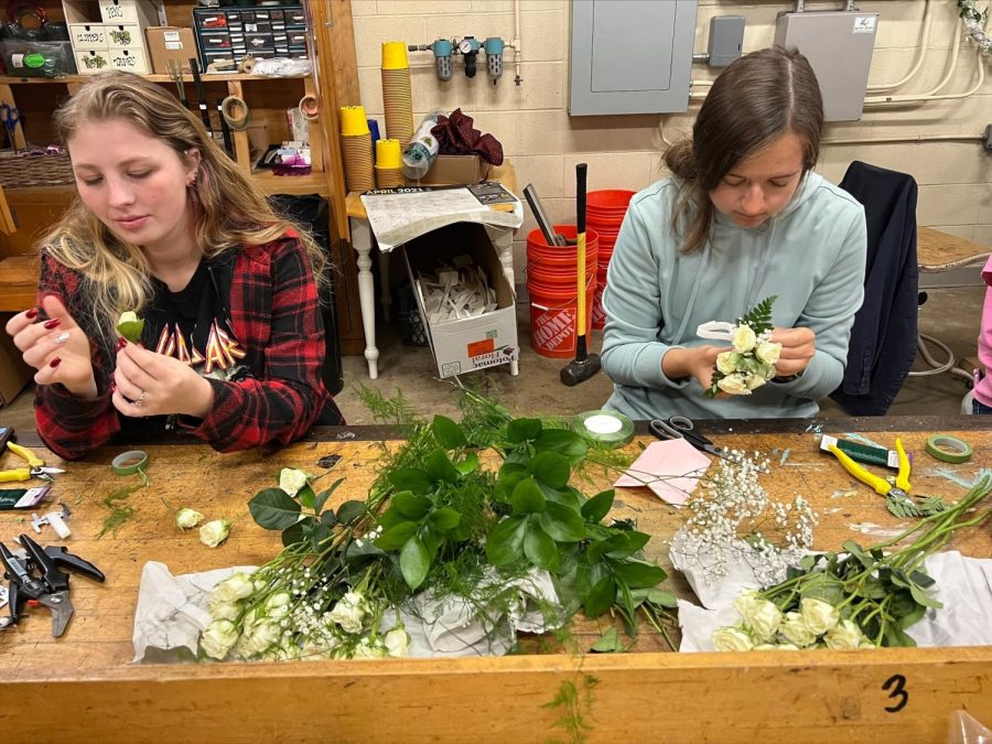 Hannah Winegardner and Meredith Day work on creating corsages and boutineers for prom. Photo courtesy of Mrs. Burton.