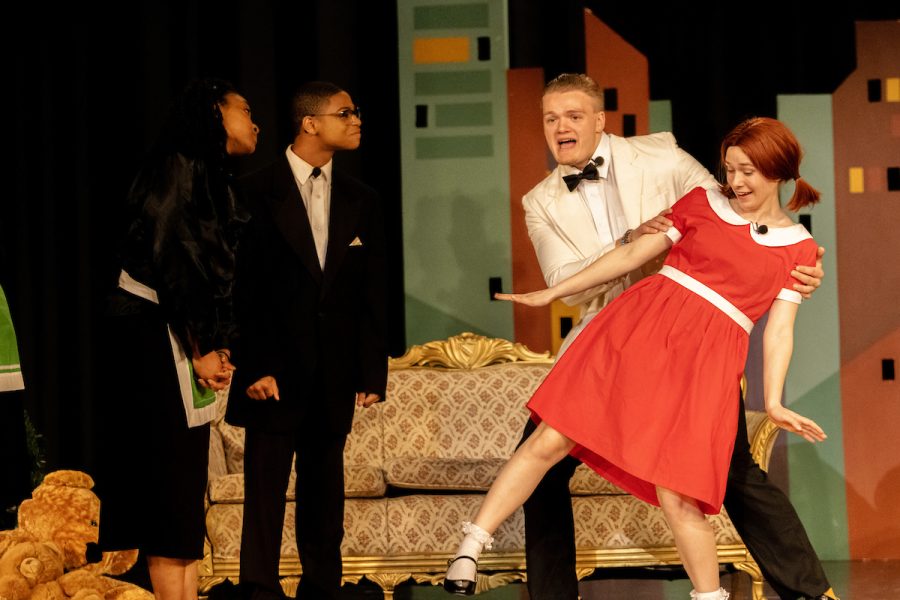 Students Samara Brooks (Mrs. Greer), Kevin Eley (Drake), Jacob Hurley (Oliver Warbucks), and Emmy Beach (Annie) perform on stage during the LHS Theater production of Annie. Photo courtesy of the yearbook staff. 