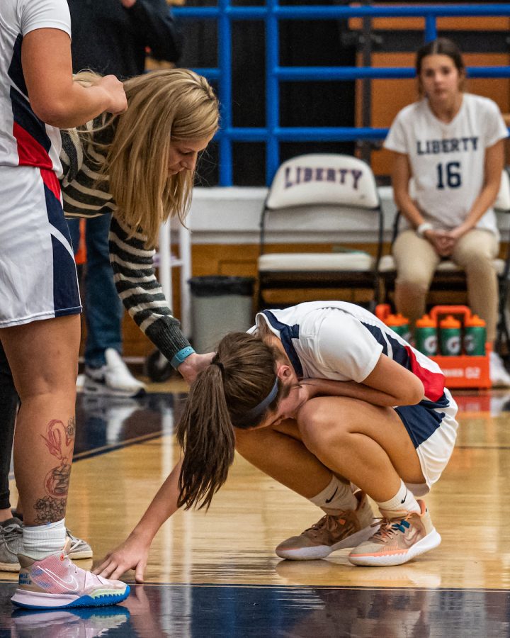 Coach Carter checks on sophomore Carleigh Cameron during an in game injury. Photo courtesy of the yearbook staff. 
